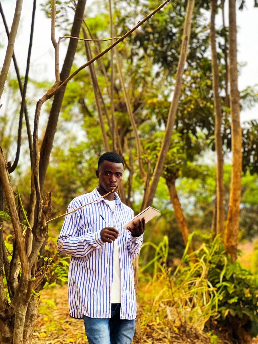 Un jeune agriculteur prenant des notes parmi les arbres